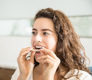 Closeup of woman putting on clear aligner