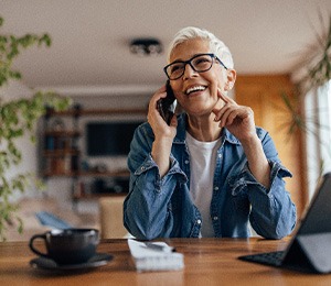 Woman smiling while talking on phone at home